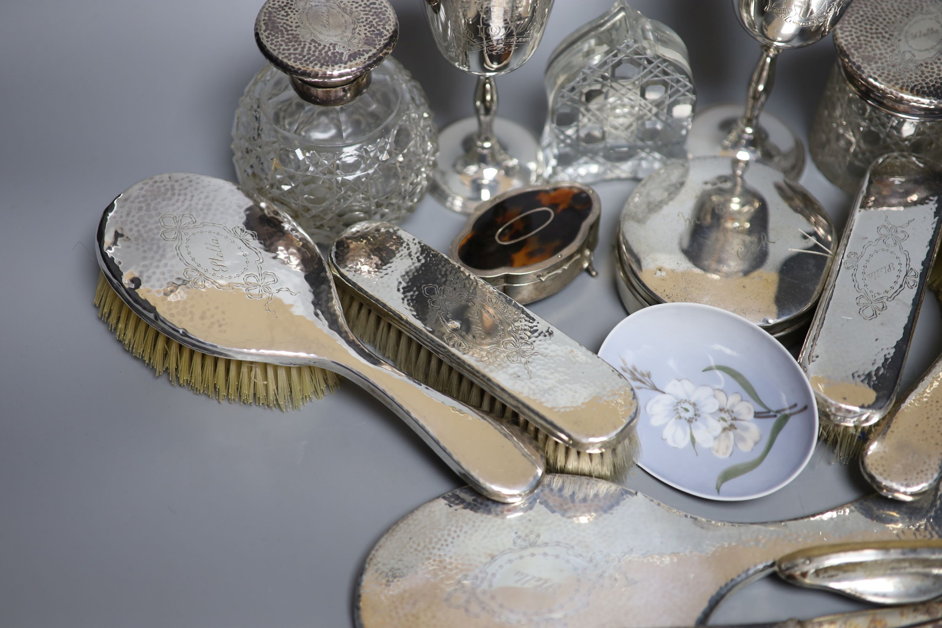 A George V hammered silver ten piece dressing table set with tray, engraved 'Stella' and six other items including a silver circular powder box?, a tortoiseshell mounted trinket box and two plate goblets.